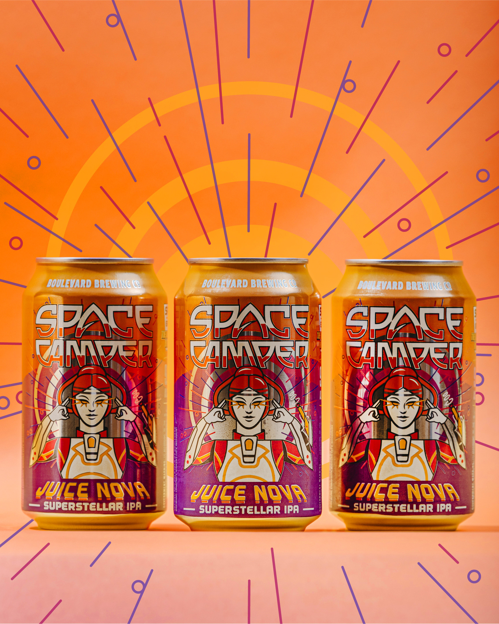 Three cans of Boulevard Brewing Co.'s Space Camper Juice Nova Cosmic IPA stand against a vibrant orange background with sunburst patterns. The cans feature a colorful design of a woman in a space suit.