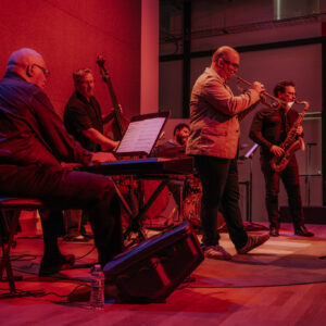 A group of jazz musicians playing music together on a stage