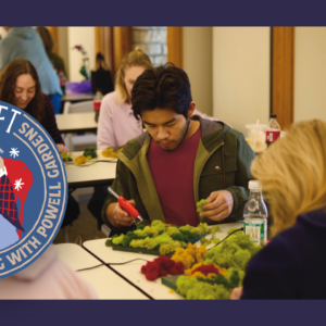 People gather at tables, immersed in crafting with greenery. A circular logo reads "Draft & Craft, Gardens, Holiday Door Swag with Powell," adorned with festive icons. The scene captures the essence of creativity and community at Draft & Craft events.