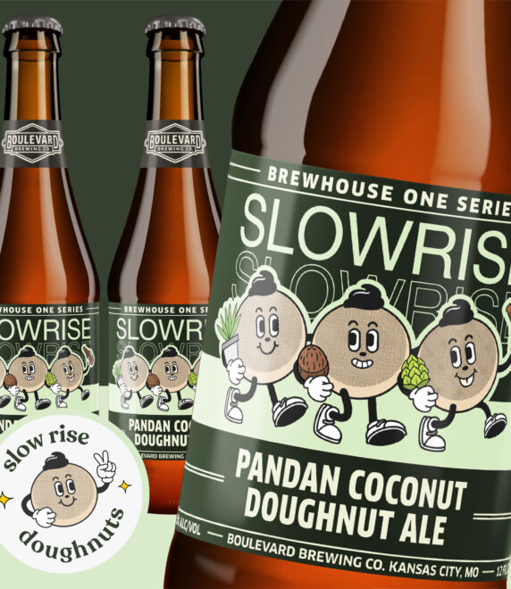 Three bottles of Boulevard Brewing Co.'s Slowrise Pandan Coconut Doughnut Ale, featuring animated coconut characters with smiling faces. The design includes doughnuts and pandan leaves. A round logo with a coconut character says "slow rise doughnuts.